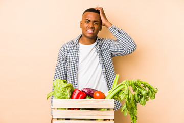 Young farmer man isolated on a beige background being shocked, she has remembered important meeting.