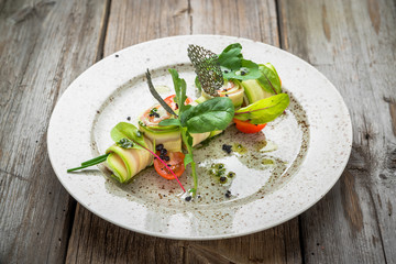 Stuffed zucchini rolled with cream cheese on complex background