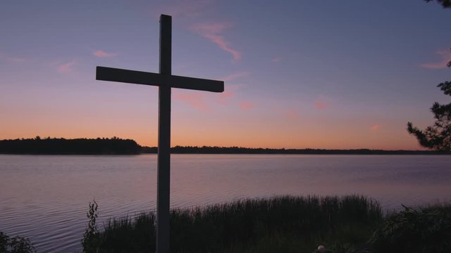 Cross on Great Lakes at sunrise in the Upper Peninsula of Michigan, subtle slider shot at Christian site