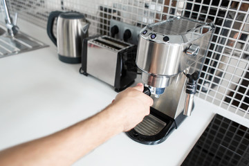 Guy prepare delicious aromatic coffee in a coffee machine. A simple way to make coffee