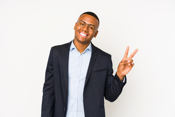 Young business latin man isolated on white background joyful and carefree showing a peace symbol with fingers.