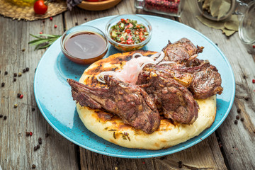 two pieces of of grilled pork with herbs on a paper