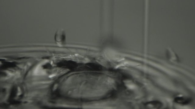 Drops of water dripping on a damp surface