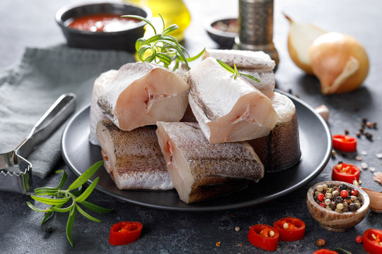 Raw fresh sliced hake fish with ingredients for cooking