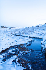 Incredible winter landscape of Iceland. In winter, a source of hot water flows in the mountains