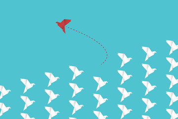Think differently concept. Be different. Red bird changing direction. New idea, change, trend, courage, creative solution, innovation and unique way concept.	