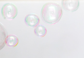 Beautiful soap bubbles fly on a white