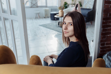 The girl looks at the audience over her shoulder. Girl's hands folded together