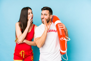 Young lifeguard couple isolated is saying a secret hot braking news and looking aside