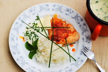 Chicken fillet, rice and chive sauce on plate and in pot.