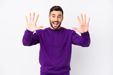 Young caucasian man against a white background isolated showing number ten with hands.