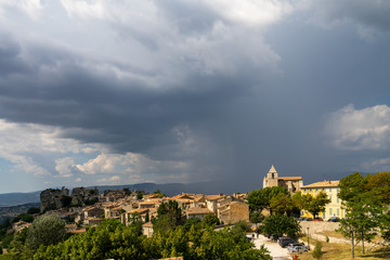 Obraz premium Rain clouds over the old town of Saignon, Provence, France
