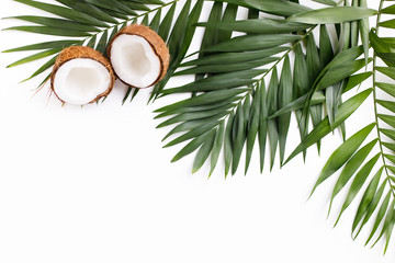 Fototapeta na wymiar Summer vibes. Vacation, paradise, ocean shore resort, tropical beach travel concept, sea coast. Palm leaves and coconut halves on white background. Summertime creative layout, copy space