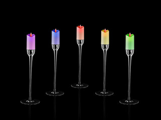 Modern style glass pastel colored candlesticks with candles and flames on the floor. Home decoration. Interior objects with isolated black  background.