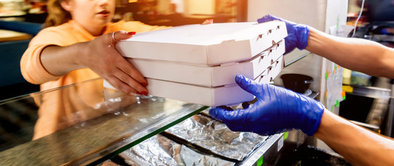 Tasty pizza in the delivery boxes. Kitchen.