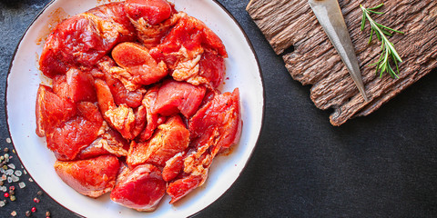 raw meat pork or beef in a plate on the table (preparing healthy food, marinade and spices paprika) menu concept background. top view. copy space