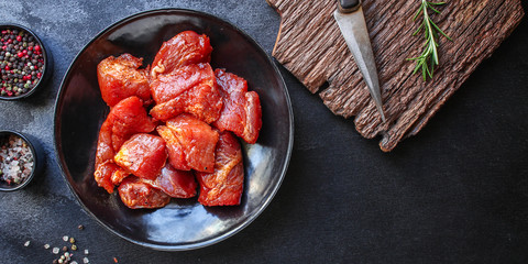 raw meat pork or beef in a plate on the table (preparing healthy food, marinade and spices paprika) menu concept background. top view. copy space