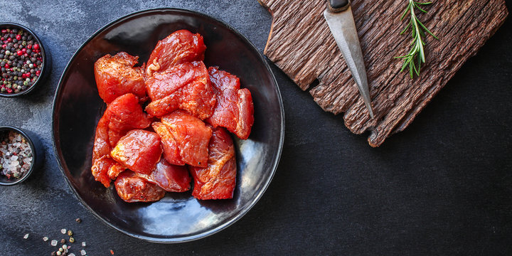 raw meat pork or beef in a plate on the table (preparing healthy food, marinade and spices paprika) menu concept background. top view. copy space