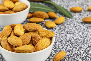 Two white bowls with almonds on gray-white marble