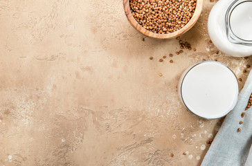Vegan Buckwheat plant based milk in bottles, closeup, brown background. Non dairy alternative milk. Healthy vegetarian food and drink concept. Copy space, top view