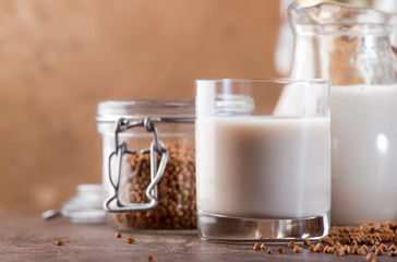 Vegan Buckwheat plant based milk in bottles, closeup, brown background. Non dairy alternative milk....
