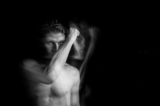 gesture raised hand. Handsome naked torso man looking to the camera. Long exposure creative artistic series of photos. fight against fears and enemies. Black and white. representation of subconscious 