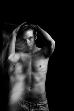 touches his head, straightens his hair. seductive naked man. Double personality back and white portrait. Long exposure creative moody creepy art works. Handsome naked torso man looking to the camera