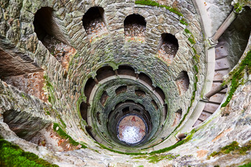The Initiation well of Quinta da Regaleira It's a 27 meter staircase that leads straight down underground and connects with other tunnels via underground. located in Sintra, Portugal. - obrazy, fototapety, plakaty