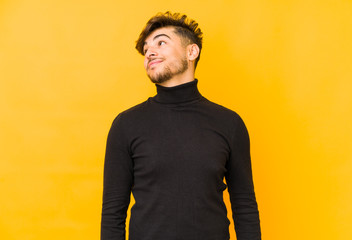 Young arabian man isolated on a yellow background dreaming of achieving goals and purposes