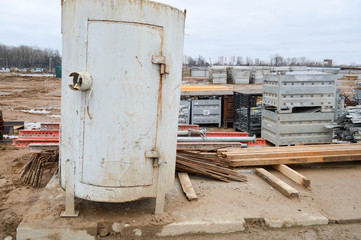 A lot of building materials with metal spare parts, sticks, beams, pipes at an open-air construction site warehouse