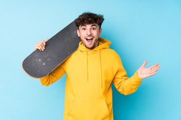 Young arab skater man isolated receiving a pleasant surprise, excited and raising hands. © Asier
