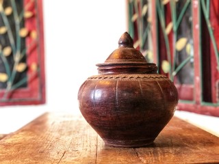Dark brown pottery jar on wooden table