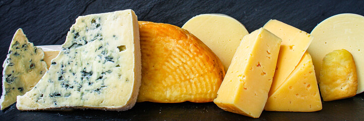 cheese background, many different types pieces on a dark (cheese product) menu concept background. top view. copy space