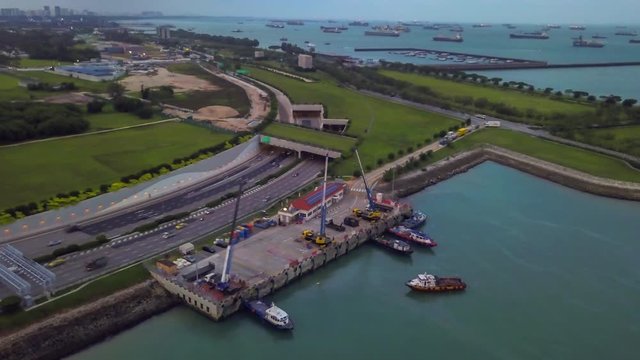 Aerial drone Hyper-lapse of City Skyline and highway traffic in Central Business District and port terminal, Singapore 2019.