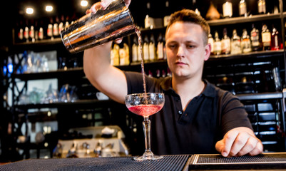Bartender is making cocktail at bar counter. Fresh cocktails. Barman at work. 
