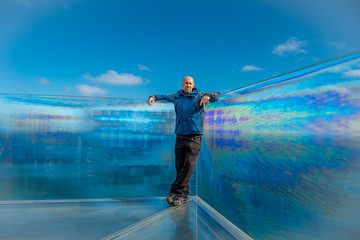 Man on glass view point on cliff, skywalk