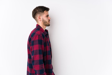 Young caucasian man posing in a white background isolated gazing left, sideways pose.