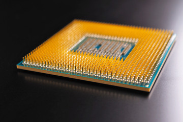 Processor of a computer lies on a dark matte surface. Close-up. CPU, semiconductors, pins and...