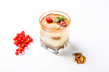Panna cotta dessert in a clear glass. The dessert is decorated with powdered sugar and cranberry...
