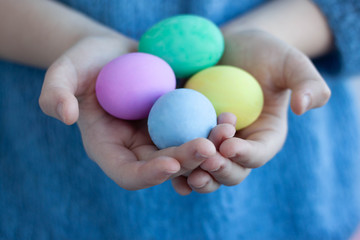 Hands are shaking four eggs painted for the Easter holiday Selective focus