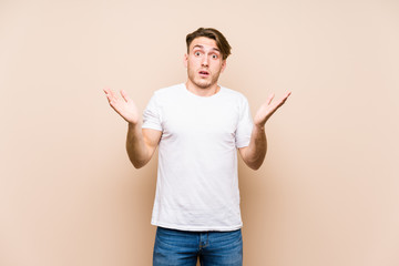 Young caucasian man posing isolated surprised and shocked.