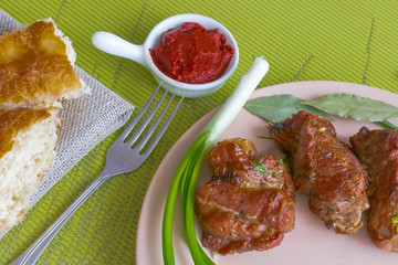 Plate with grilled meat skewers, bread and spices. Harmful and hazardous food containing carcinogens.
