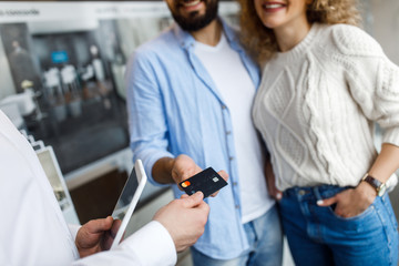 Close up photo, sale, consumerism, shopping and people concept - happy couple with credit card at decoration store in mall