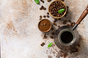Morning coffee concept. Turkish coffee in Turk and coffee beans on a stone or slate countertop. Top view flat lay background. Copy space.