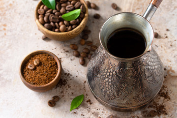 Morning coffee concept. Turkish coffee in Turk and coffee beans on a stone or slate countertop.
