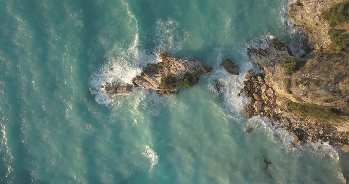Aerial view of small beach with turquoise water next to rocks and trees in the area of Agia Paraskevi Halkidiki, Greece. View from drone	