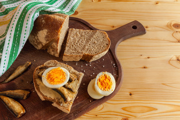 scandinavian breakfast with boiled egg, small fish and rye bread. ingredients for sandwiches. horizontal
