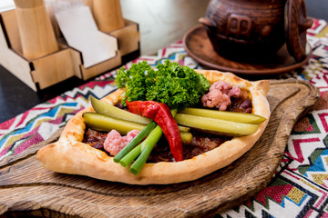 Khachapuri with cheese, vegetables and eggs. Georgian national cuisine. 