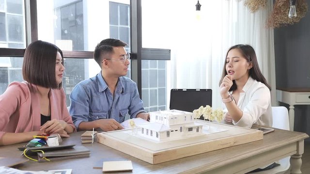 Asian  Interior Architect working with architectural model choosing material and study mass model house design ideas concept.Designer group brain storming in a meeting idea for new house.