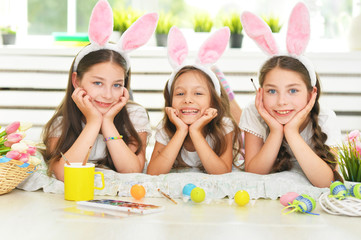 Obraz na płótnie Canvas Cute girls wearing rabbit ears decorating Easter eggs